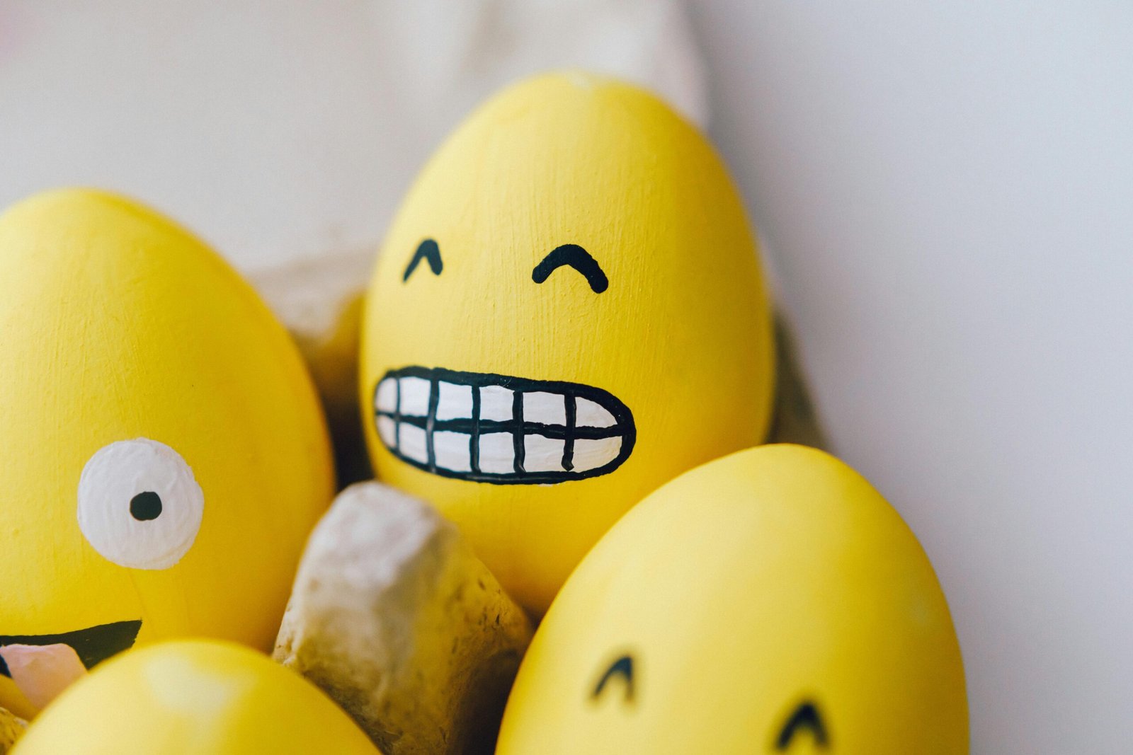 Huevo pintado de amarillo con una cara sonriente.
